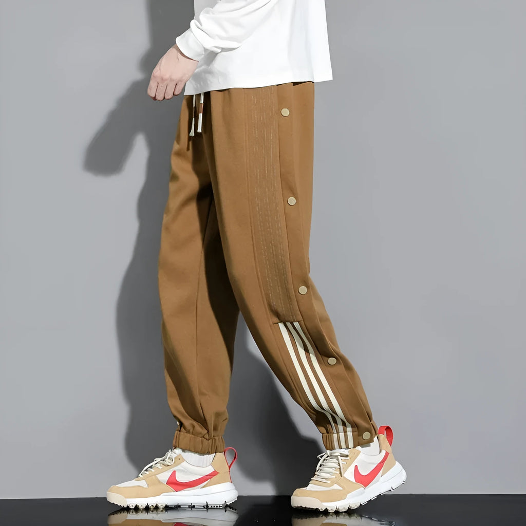 Man wearing loose grey sweatpants with ankle ties and a high waist.