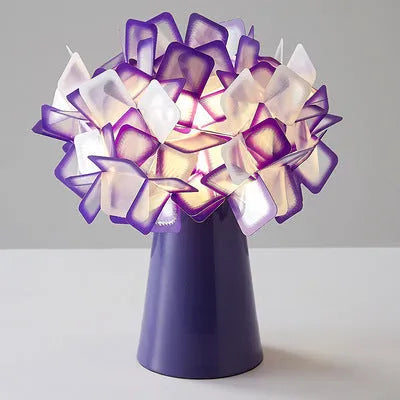 Nordic style decorative table lamp with metal base in a choice of six colours on a wooden bedside table.
