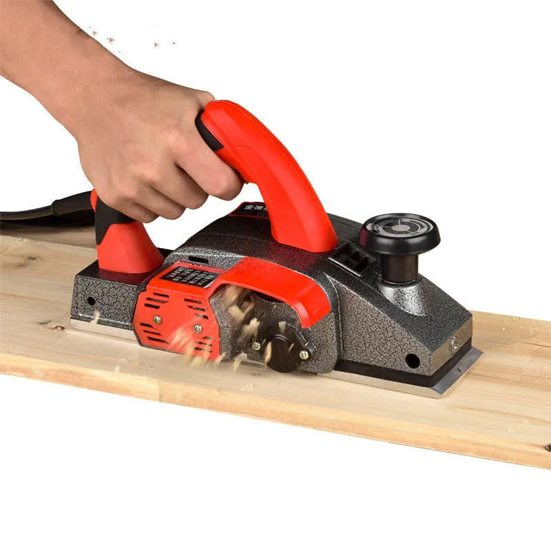 Red desktop electric wood planer with aluminium housing showing 82mm planing width