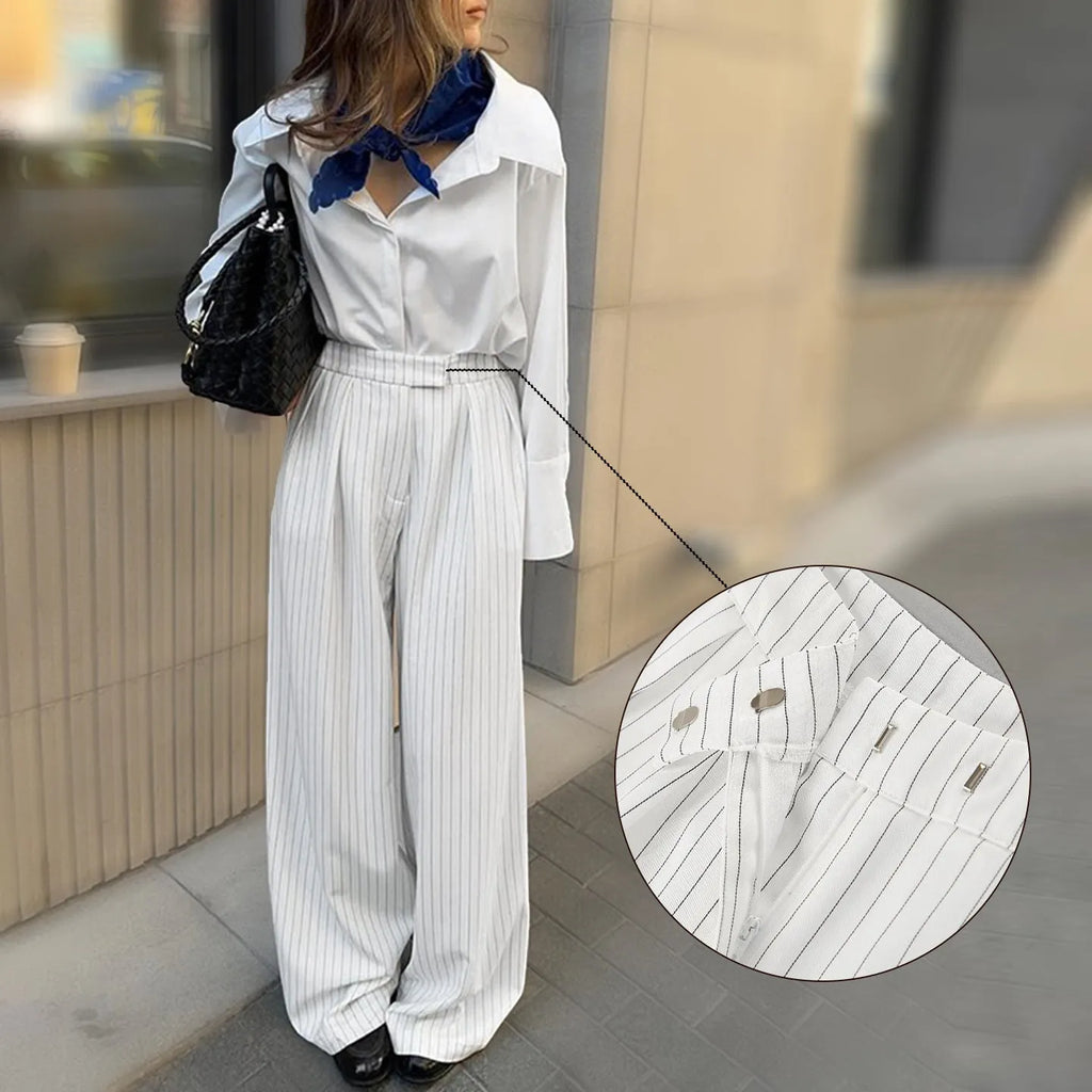 Women's white striped wide-leg trousers with front zipper closure on hanger