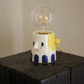 Handmade ceramic table lamp with a spherical ball headlight shade on a ceramic base.