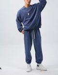 Men's polar fleece tracksuit set showing crew neck top with padded trousers in winter sportswear style