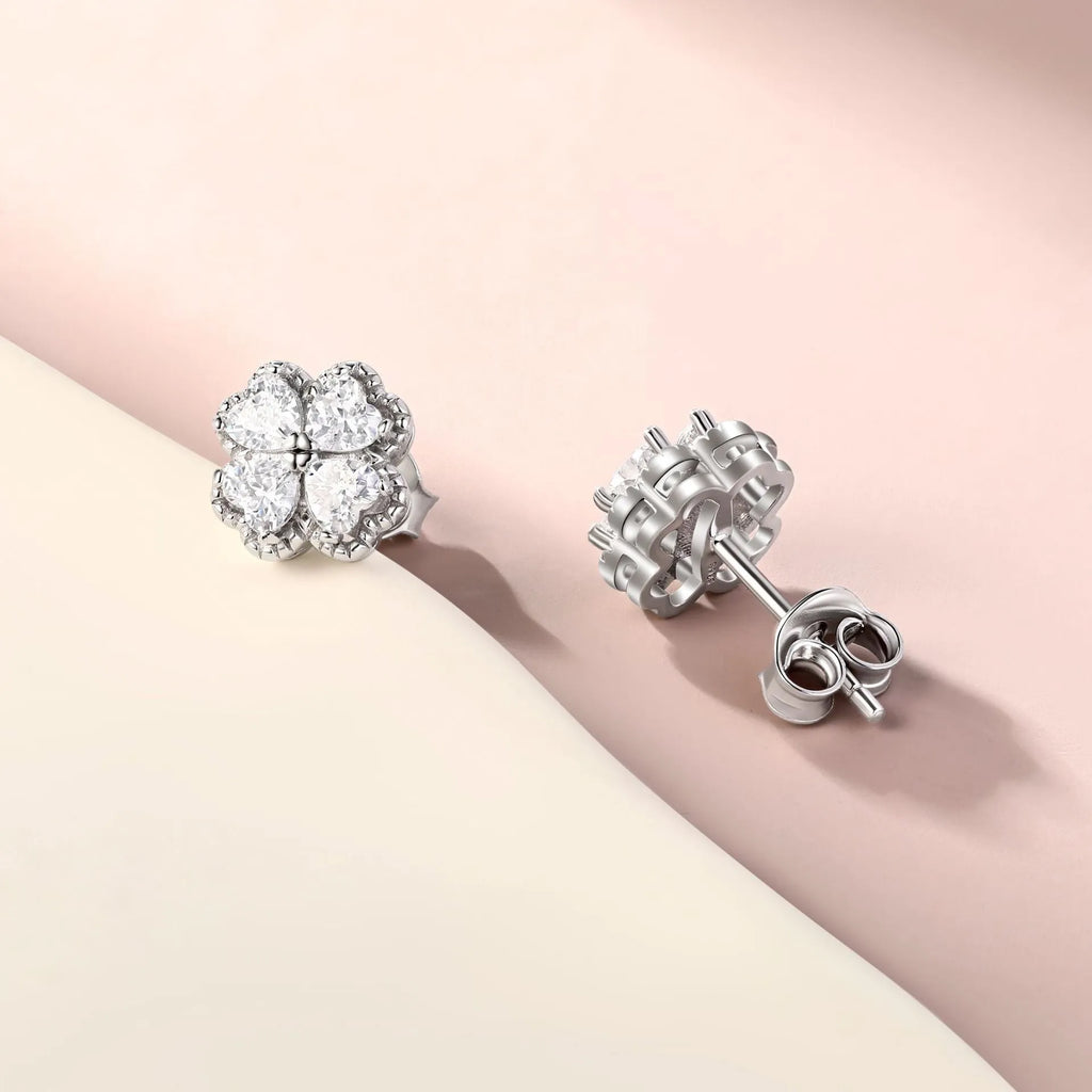 Pair of heart-shaped silver earrings with a four-leaf clover design and zircon stones.