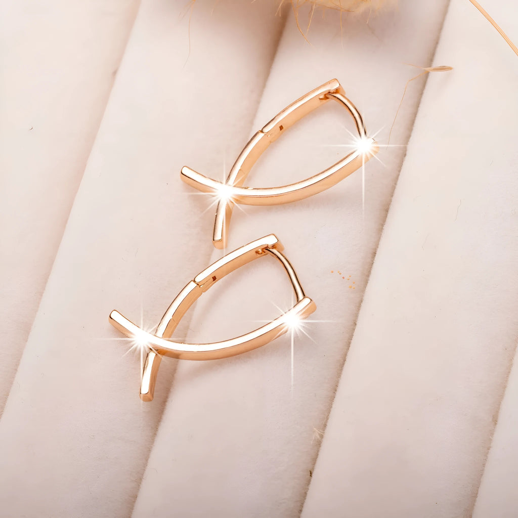 Rose gold plated cross-shaped drop earrings on a copper base.