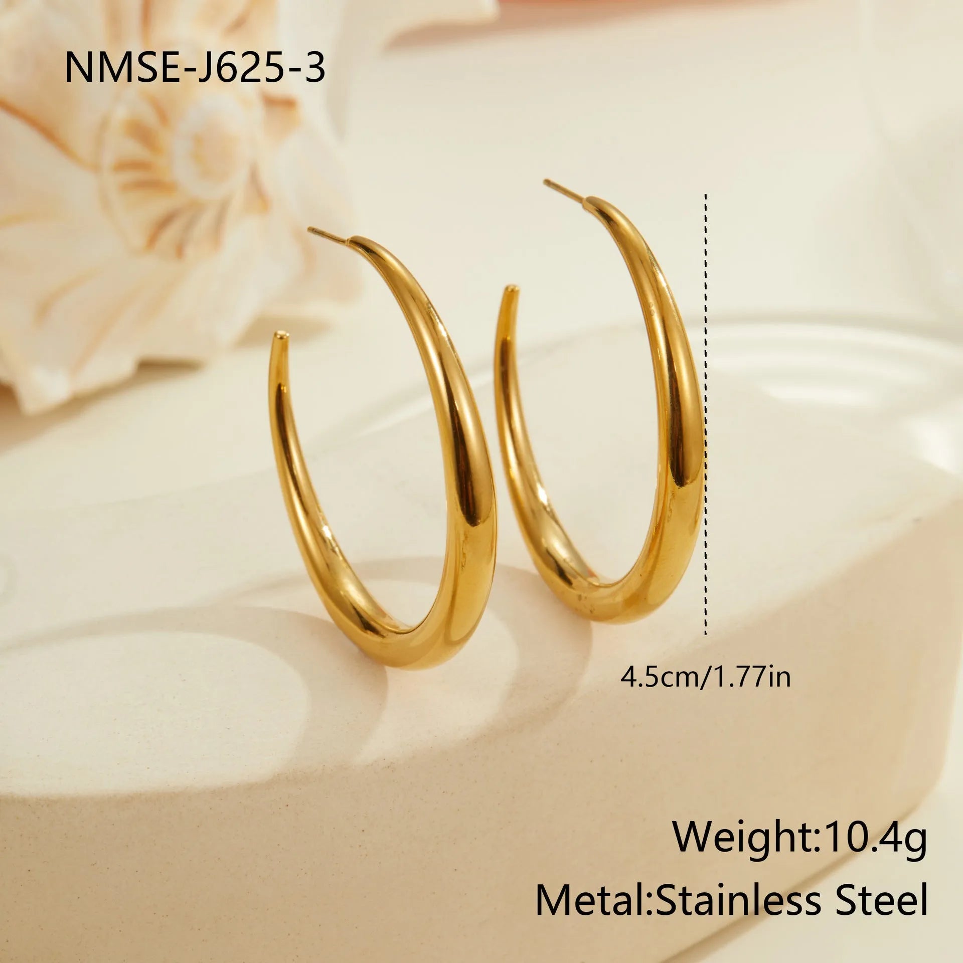 A pair of simple round titanium stainless steel hoop earrings shown in both gold and steel finishes.