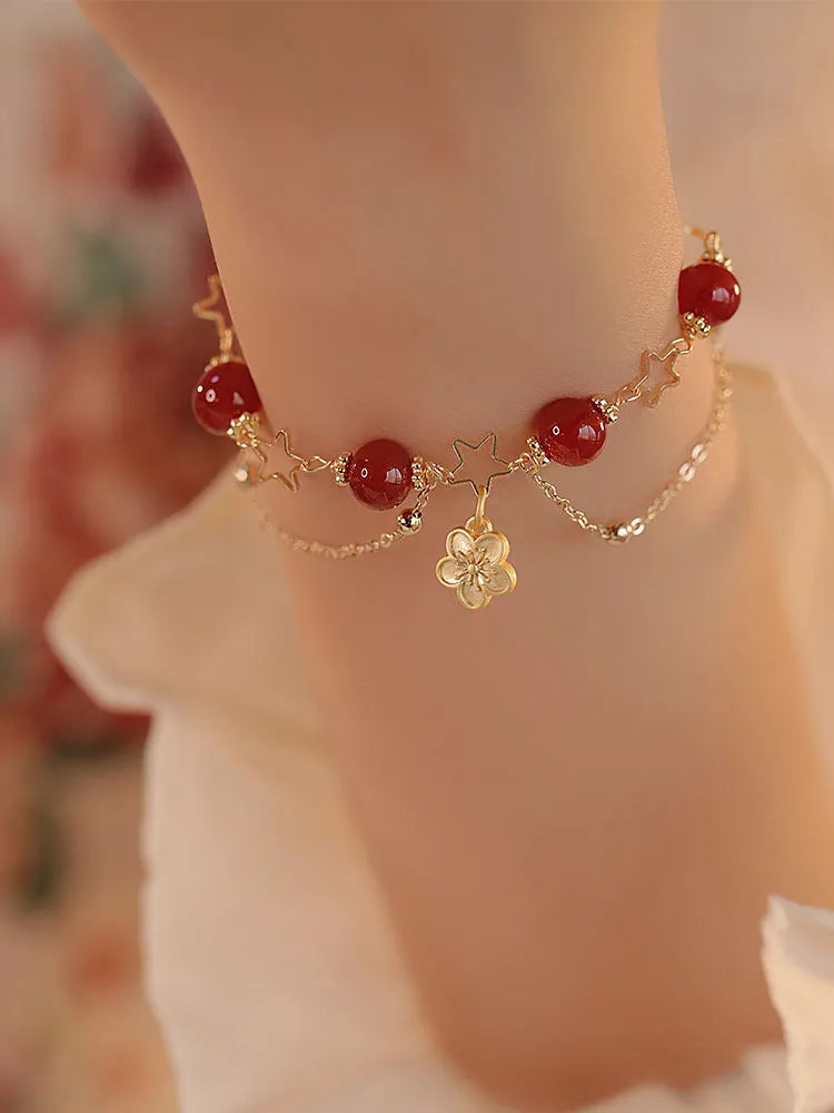 Handmade red agate double layer bracelet with floral peach blossom design on a white background.
