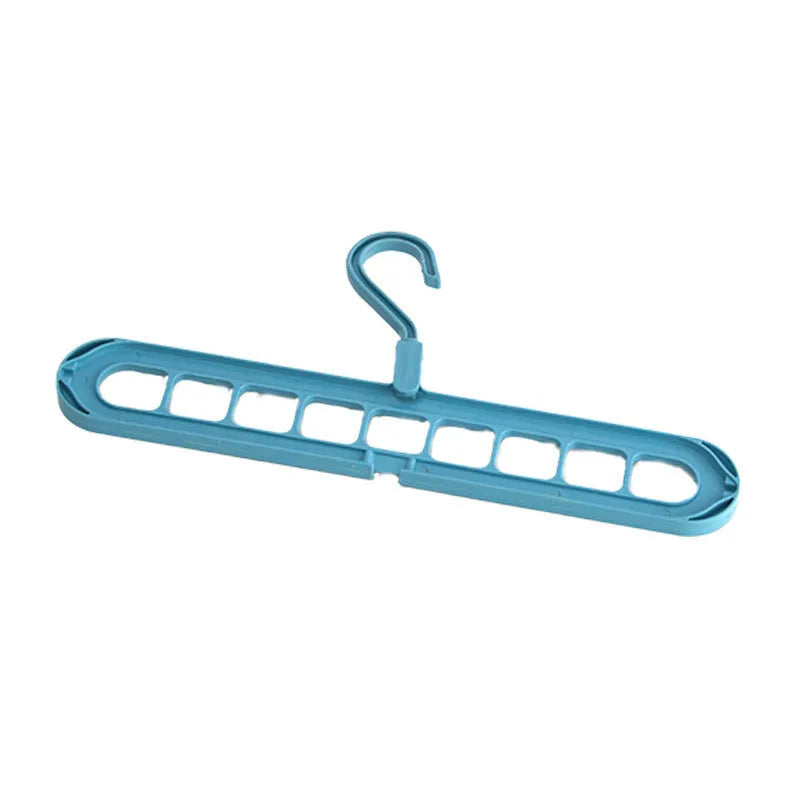 Green plastic folding clothes hanger with nine holes for organising trousers on a rack.