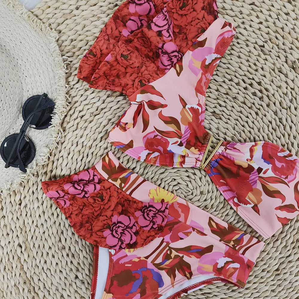 Women's pink one-shoulder ruffled bikini with red flowers and high-waist briefs.