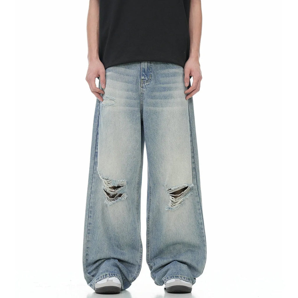 Men's blue straight leg jeans with ripped detailing on a cotton blend fabric.