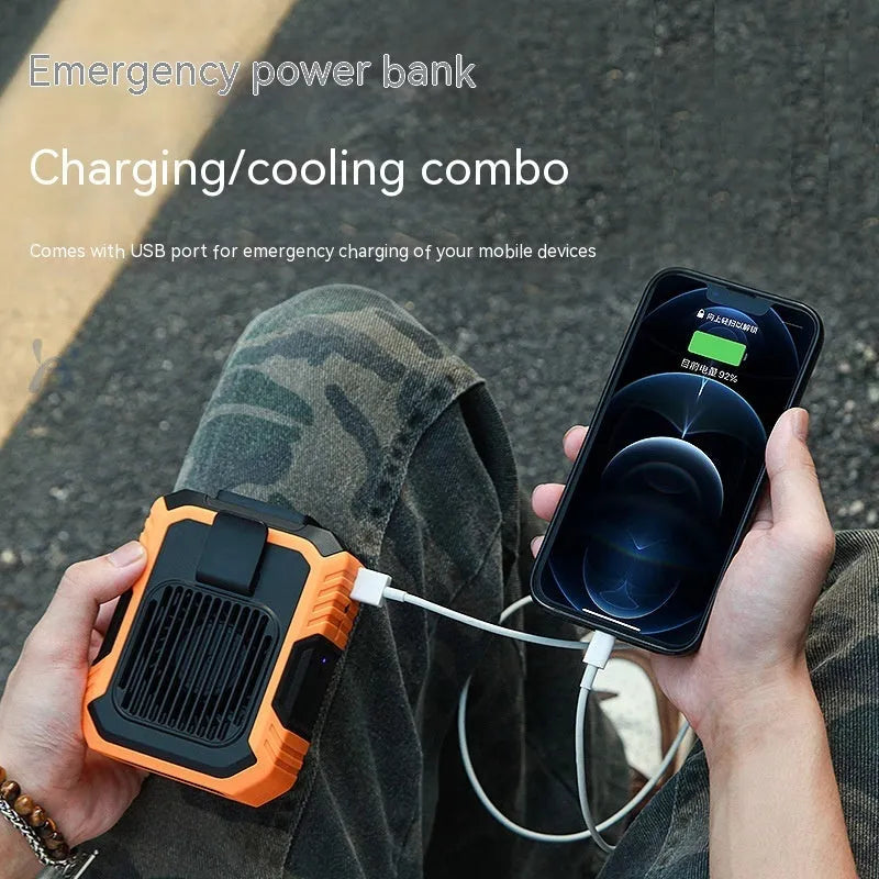 Green wrist-hanging portable fan with integrated light and USB charging port on a white background.