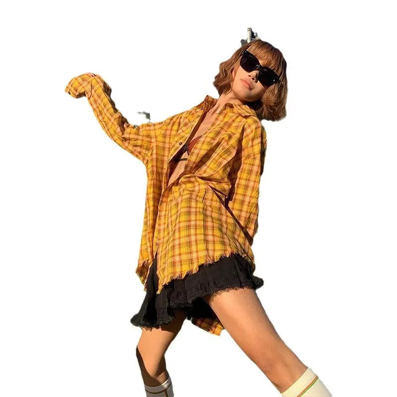 A loose yellow and black plaid shirt with a cardigan style, shown on a hanger.