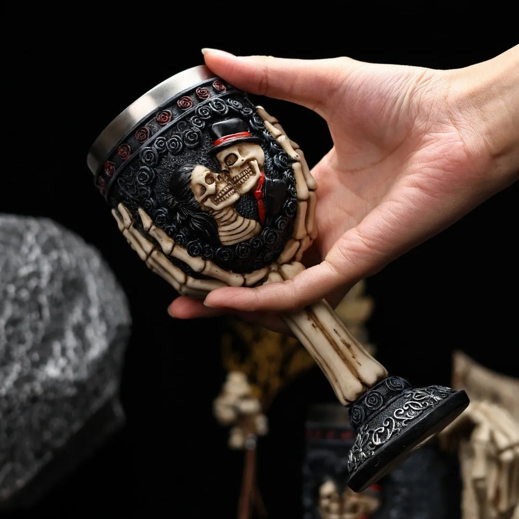 A pair of stainless steel wine glasses with a detailed red human skeleton pattern on a black background.