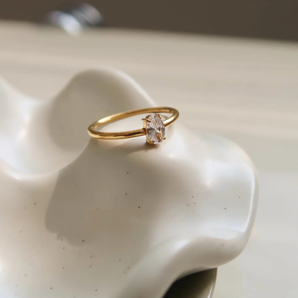 Golden stainless steel ring with heart shape or oval design on female hand
