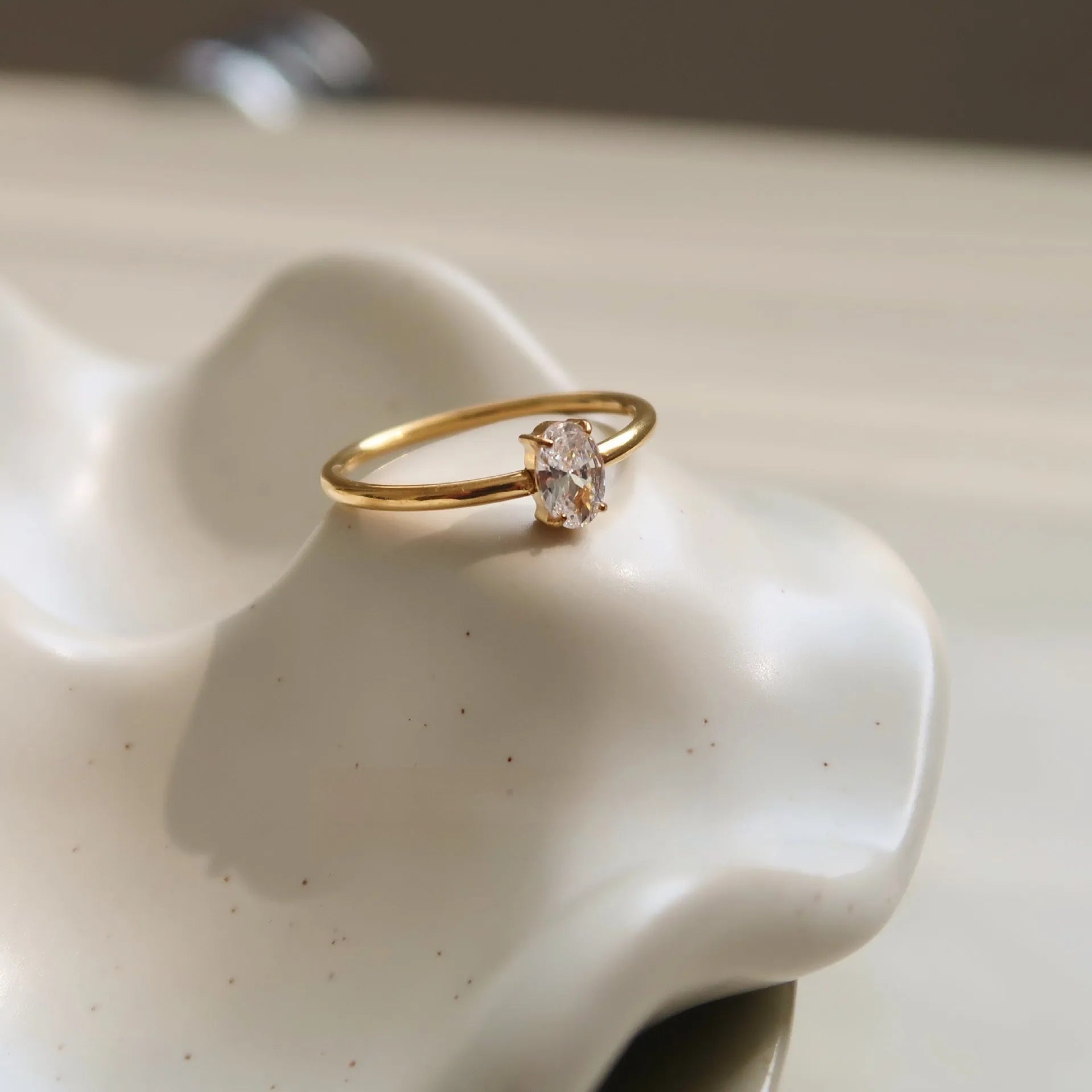 Golden stainless steel ring with heart shape or oval design on female hand