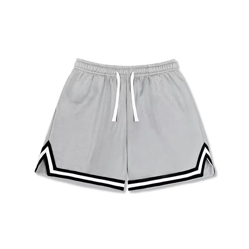 Man wearing loose fit grey polyester sports shorts on a summer day.