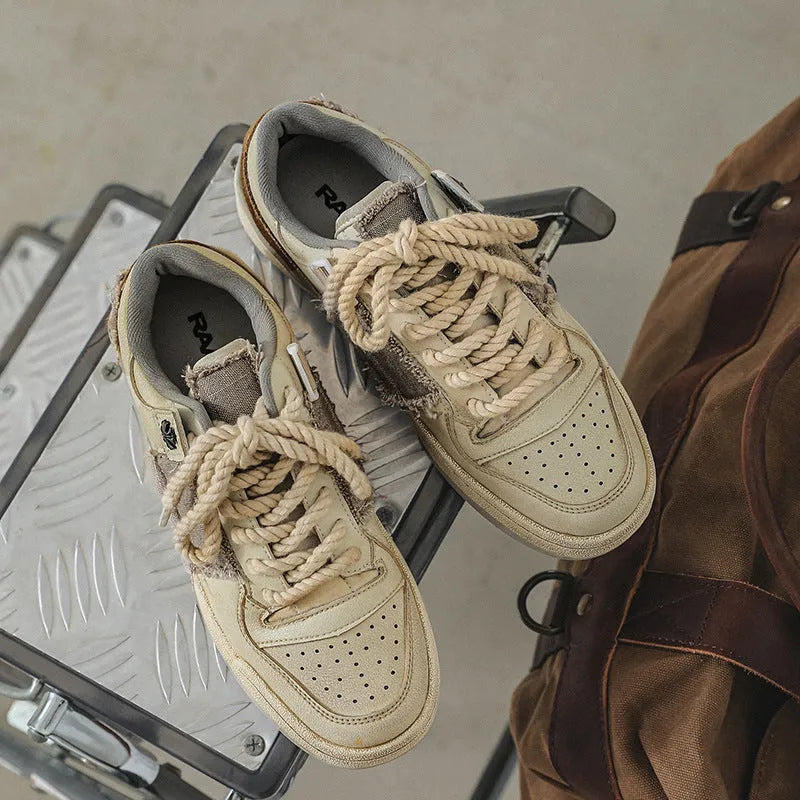 Beige low-top skateboard shoes with round toe and front lace-up closure on a flat rubber sole.