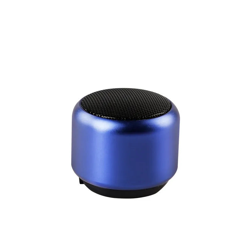 Small portable Bluetooth speaker in black, blue, gold, or pink colour on a table.