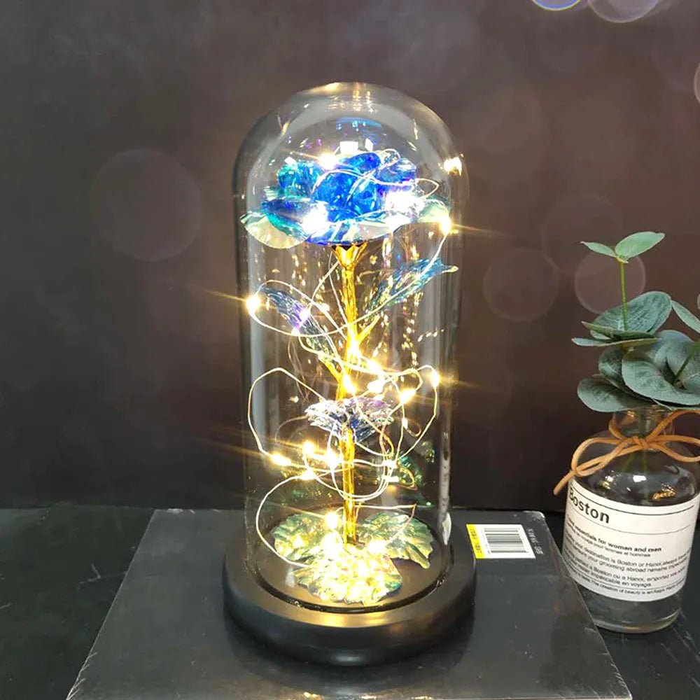 LED illuminated silk rose bouquet in a glass dome on a wooden base, with warm white lights.