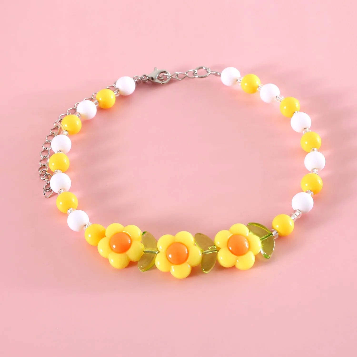 Colourful plastic bead cat necklace in rainbow, peach, or small flower pattern on a white background.