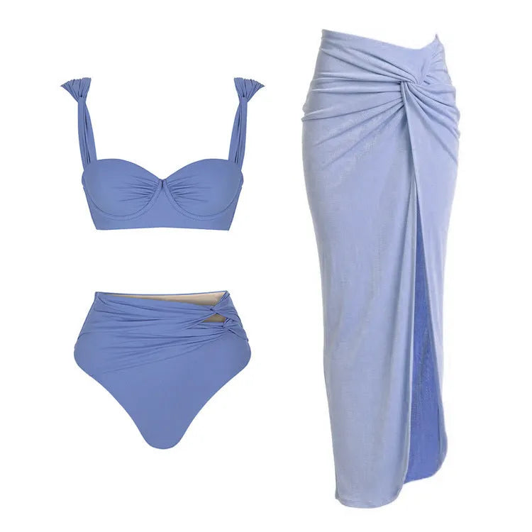 Women's solid colour one-piece swimsuit with gold buttons and a matching skirt.