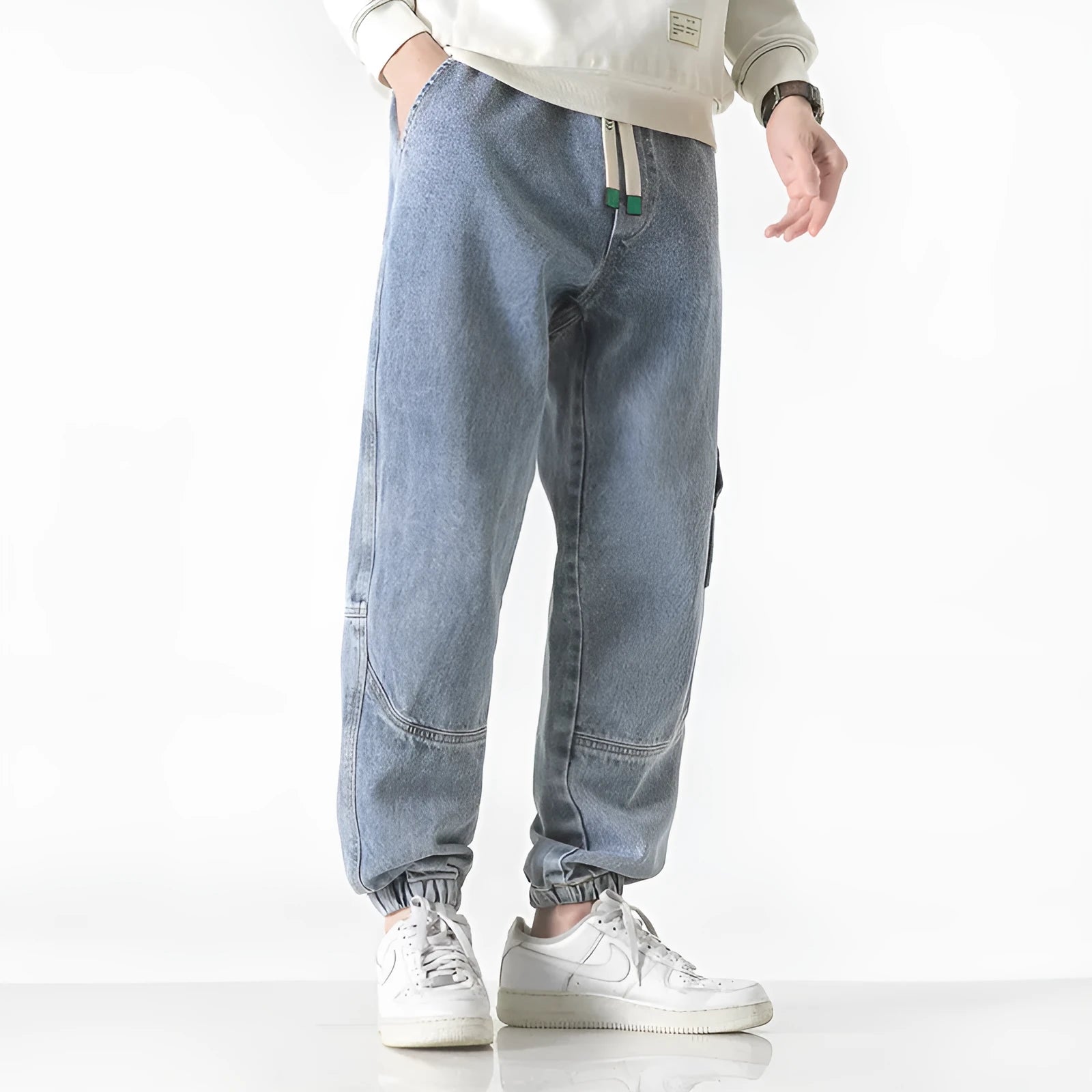 Men's loose-fit tapered cotton trousers in grey on a hanger.