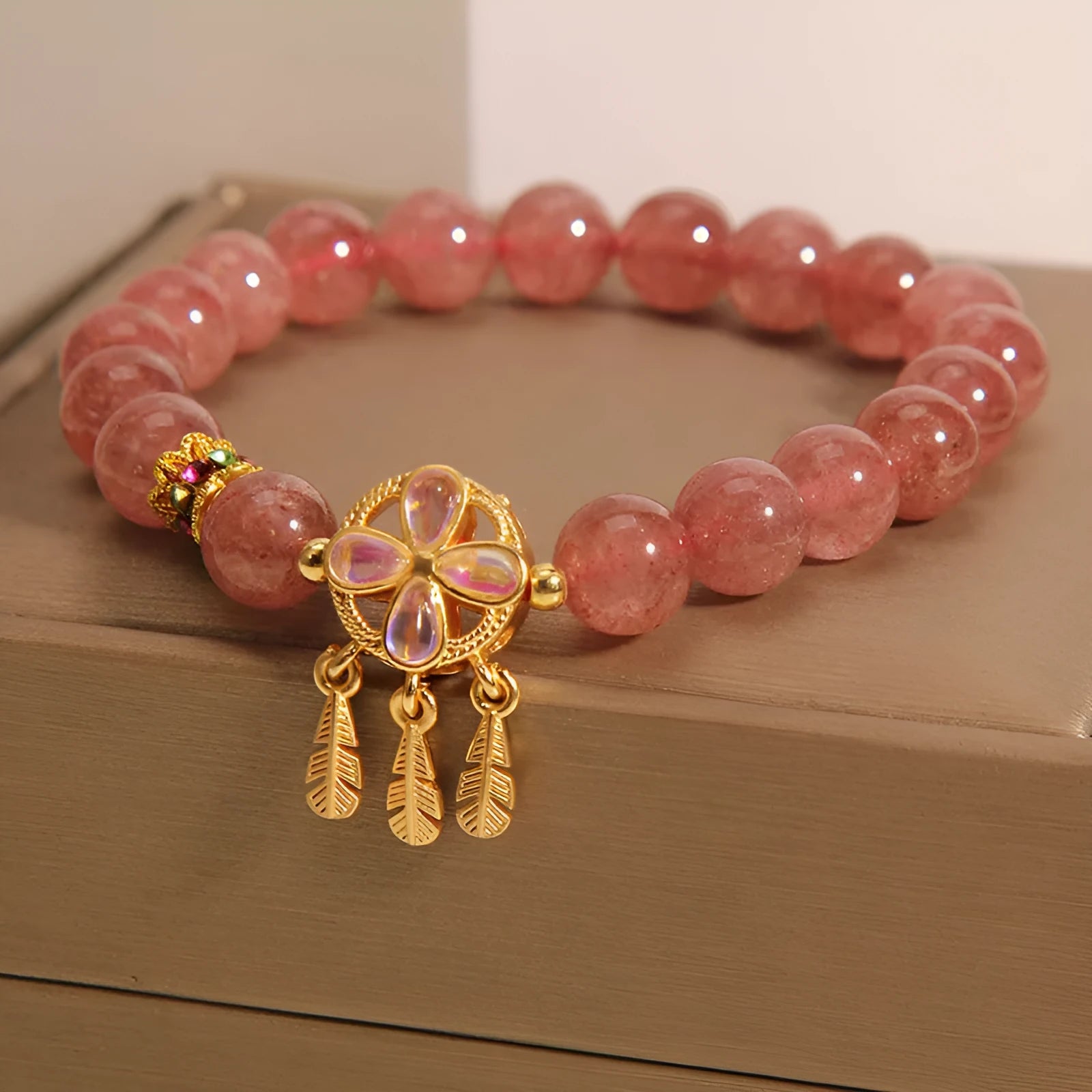 Women's strawberry quartz crystal bracelet with four leaf dream catcher pendant.