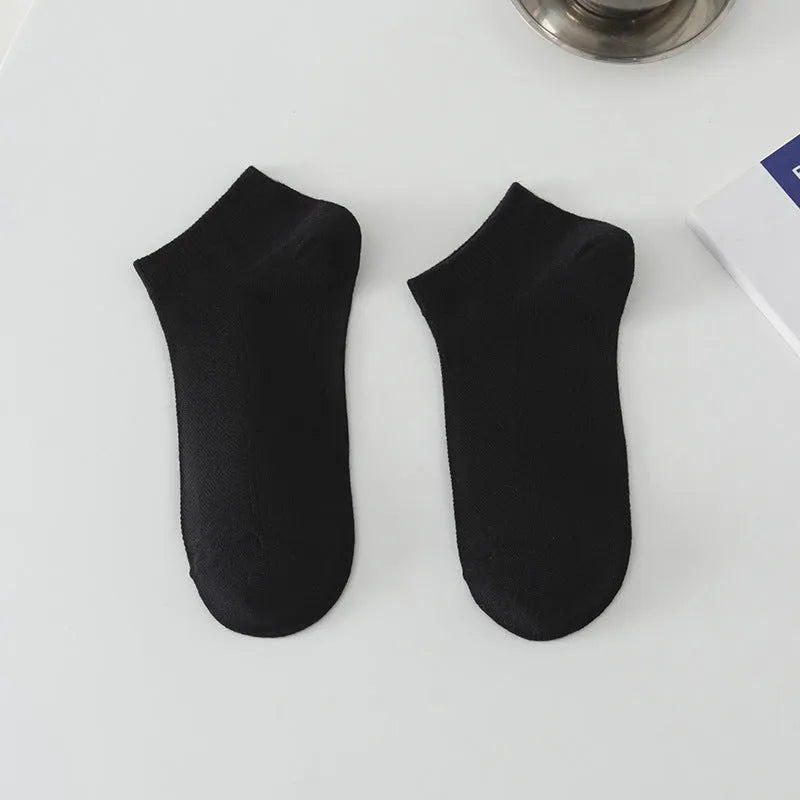 A pair of solid colour low-cut polyester boat socks for men, shown in one of six available colours.