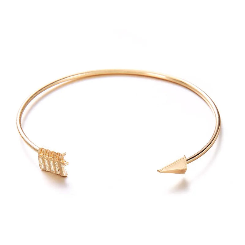 Gold vintage women's cuff bracelet with arrow and knotted design details.