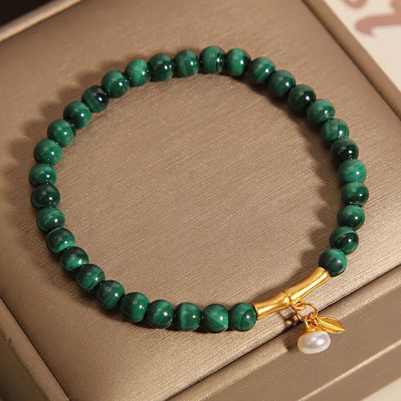 A women's adjustable bracelet made of white crystal with a lucky bamboo charm on the wrist.