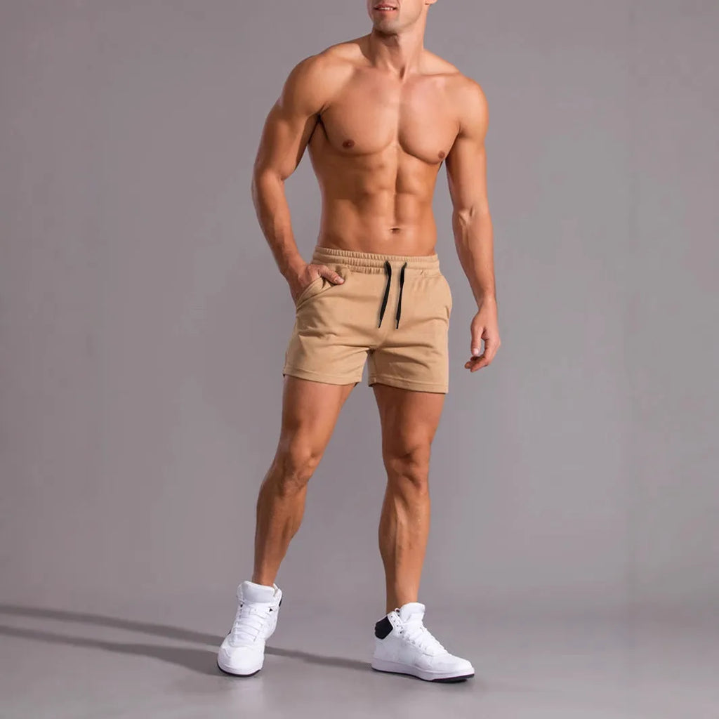 Pack of three men's solid colour drawstring shorts in black, khaki, and light brown on a hanger