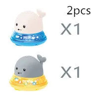 Blue and white whale bath toy with water spray and flashing lights for baby sensory play