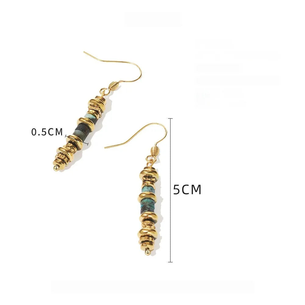 A pair of geometric-shaped, gold-coloured titanium steel dangle earrings on a white background.