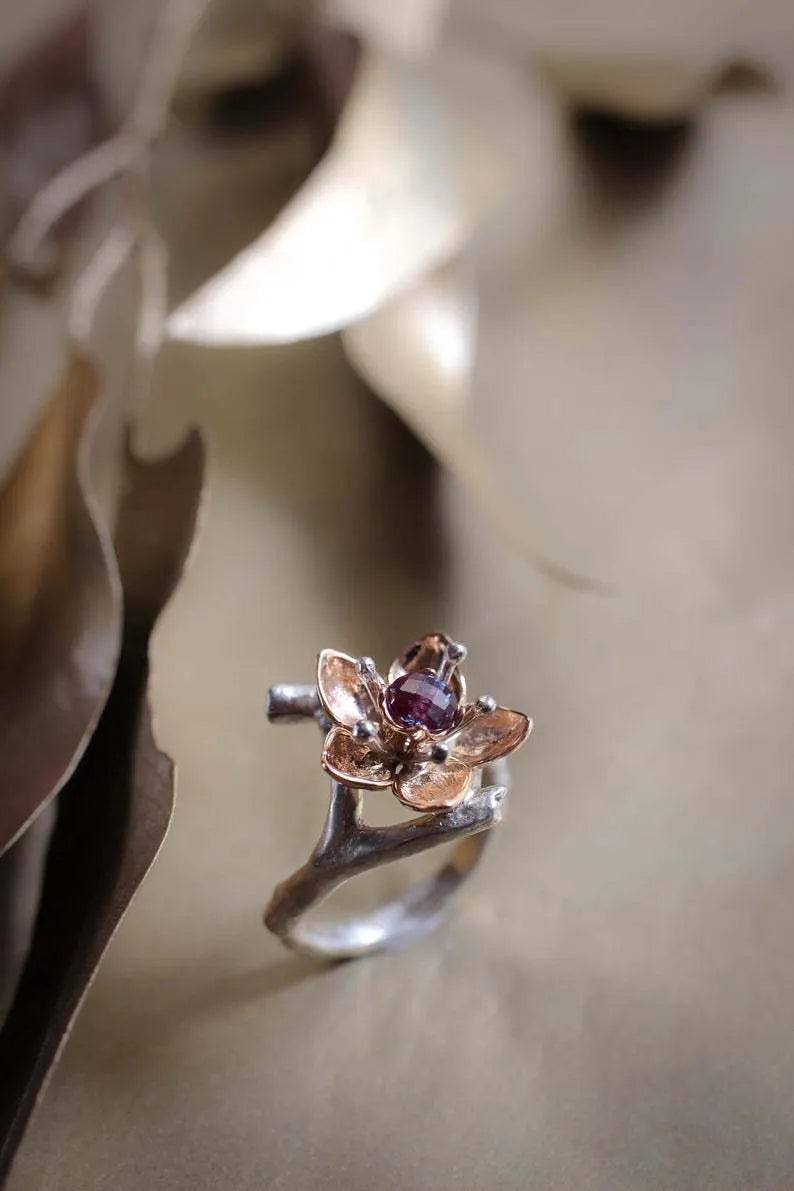 Silver two-tone floral design women's alloy ring on a simple geometric band.