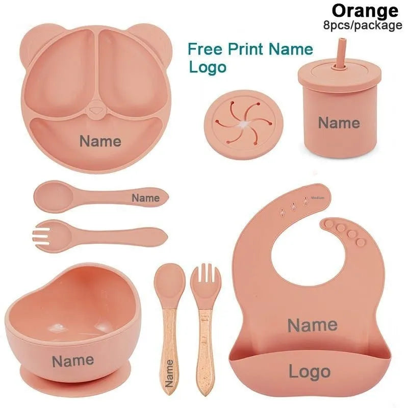 Children's silicone tableware set with cat ear cup in beige, blue and other colours on a table