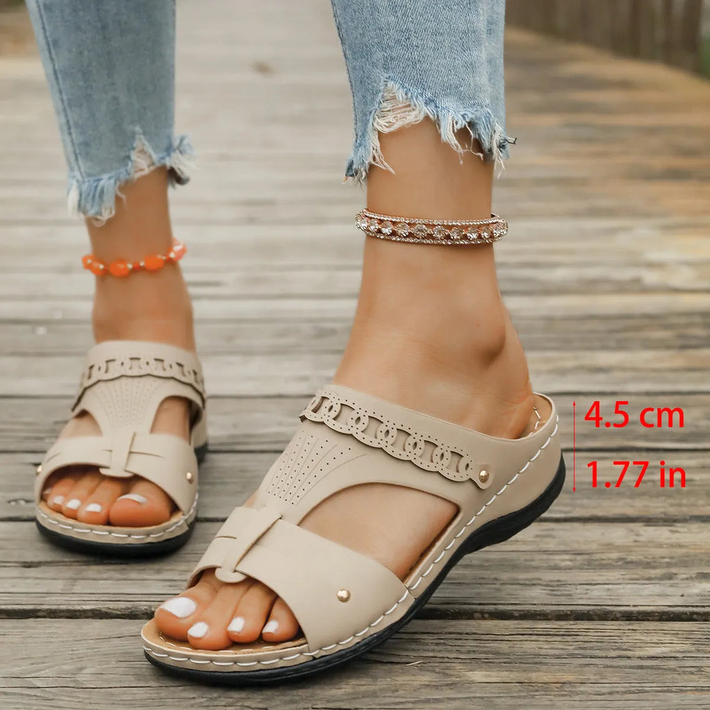 Women's beige Roman style slippers with a slope heel and fish mouth toe holder on a rubber sole.