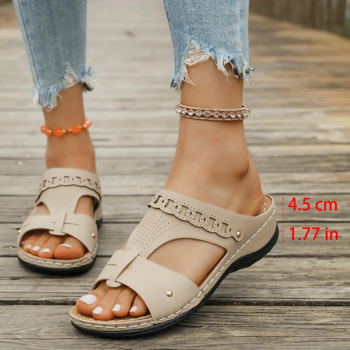Women's beige Roman style slippers with a slope heel and fish mouth toe holder on a rubber sole.