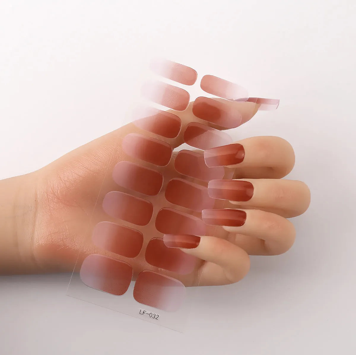 Full sheet of nail art stickers showing sixteen small designs including cross, rose, tulip, and leopard print patterns.