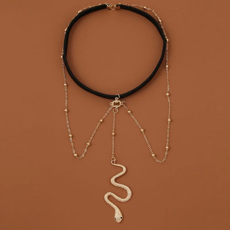 Gold metal beaded thigh chain with large snake pendant and artificial gem inlay, worn on a woman's leg
