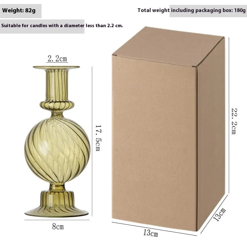 Transparent borosilicate glass three ball mott candle holder in green on a table