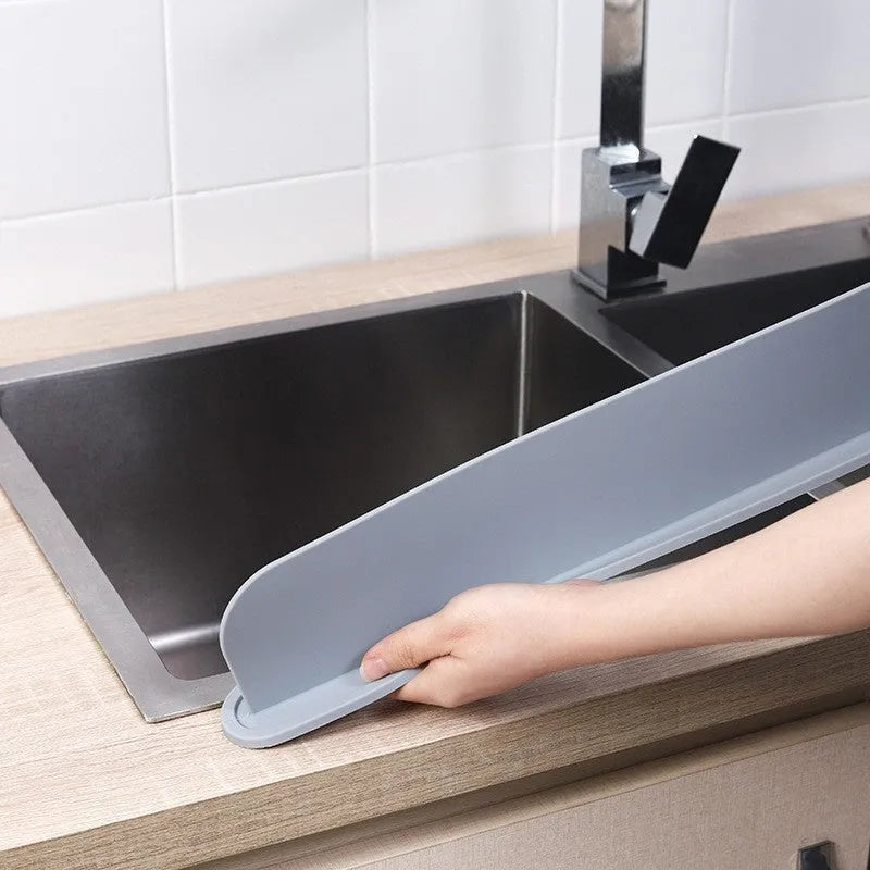 A thick grey silicone kitchen sink water blocking plate or splash guard measuring 52mm by 85mm.