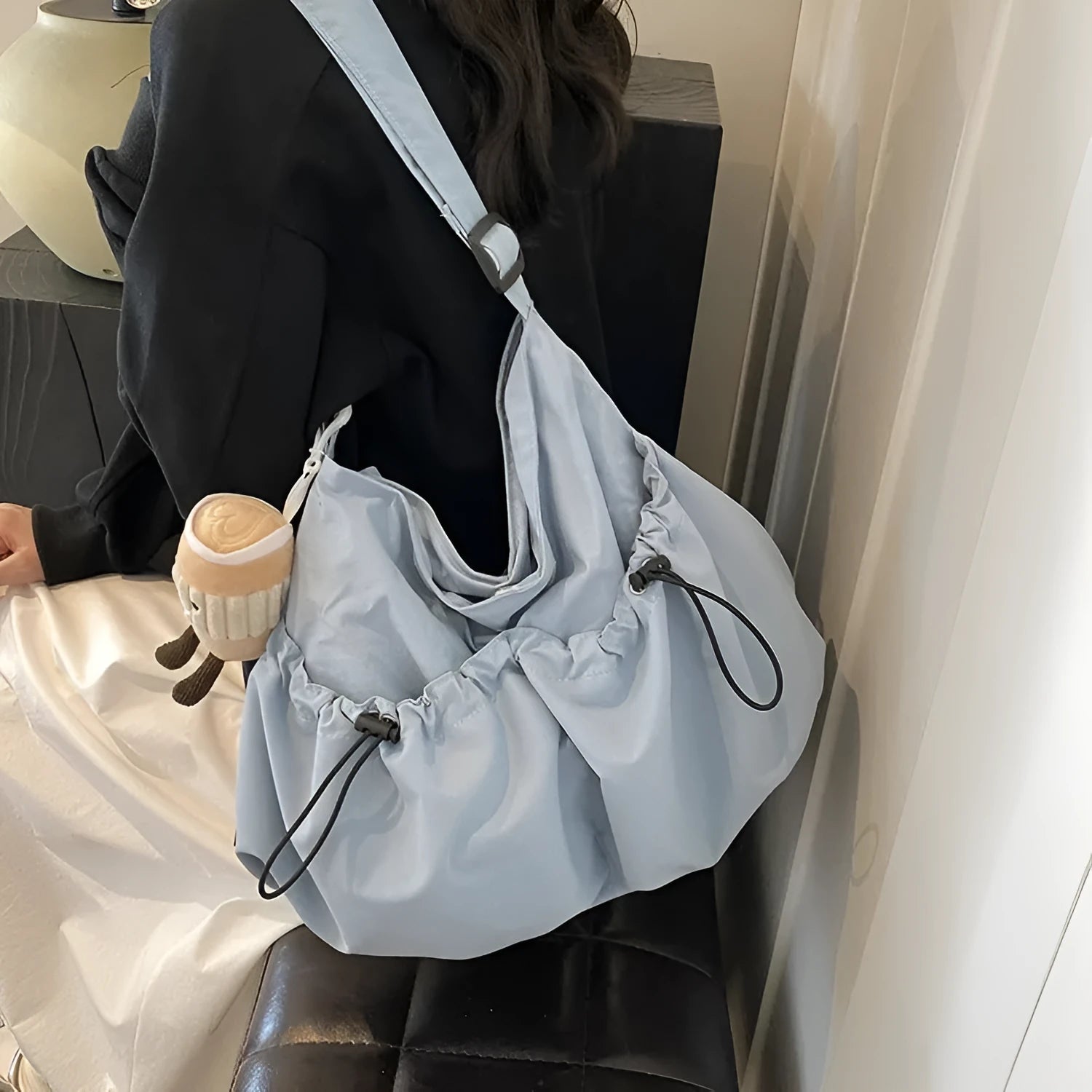 Pleated foldable polyester crossbody student bag in multiple colours showing split pocket and compact 35cm dimensions