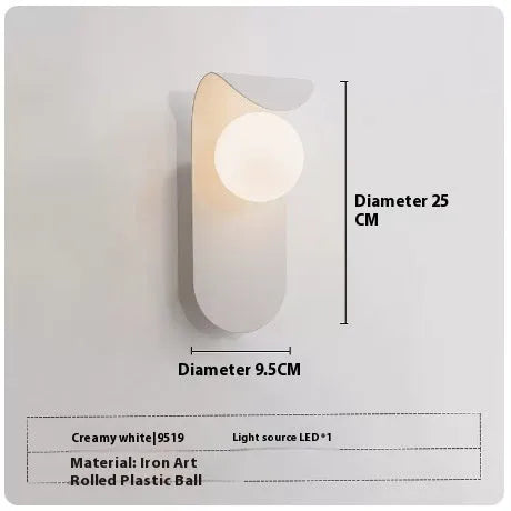 Modern minimalist black wall lamp with iron shade and LED light on a bedroom wall