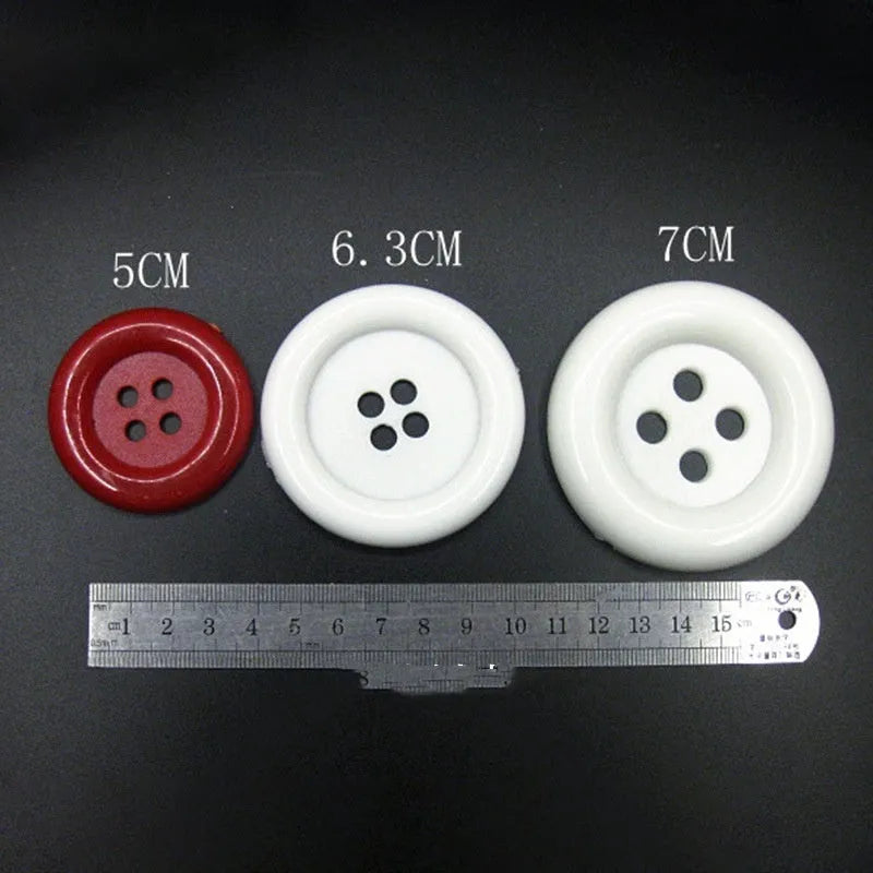 Assortment of oversized round plastic buttons in multiple colours with four stitching holes.