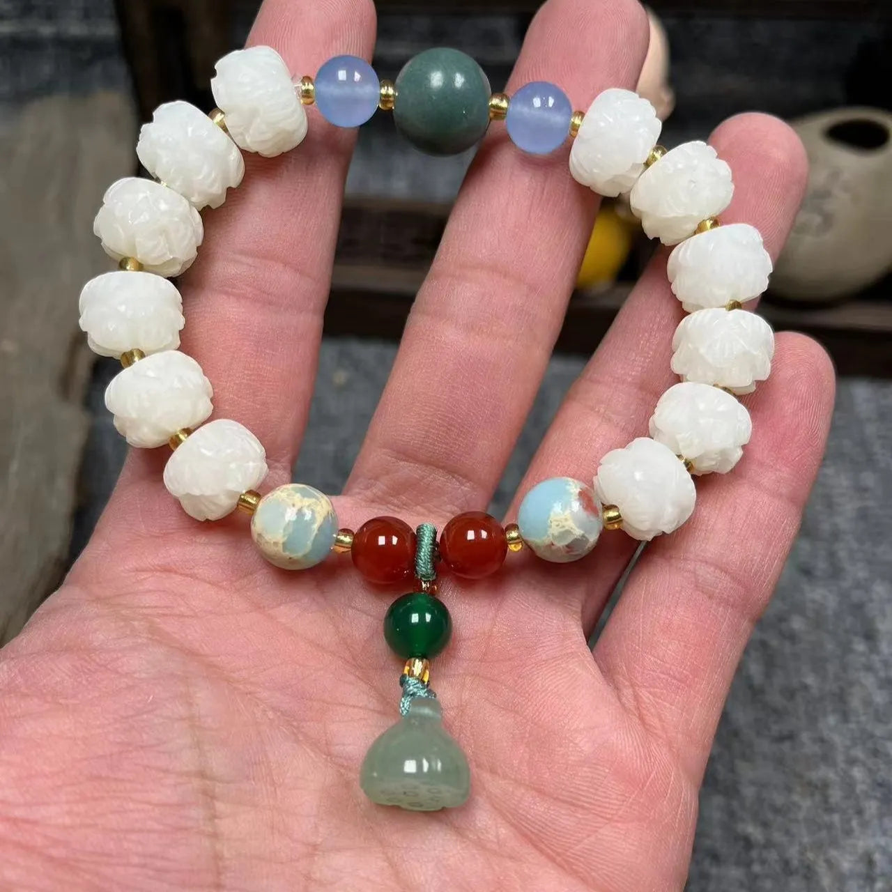 Carved Bodhi root bracelet with white jade, lotus, and pumpkin beads in various sizes.