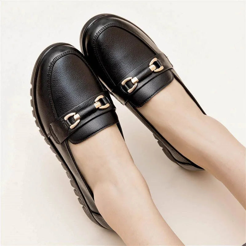 Black soft leather pumps with a round toe, low flat heel, and shallow cut design on a plain background.
