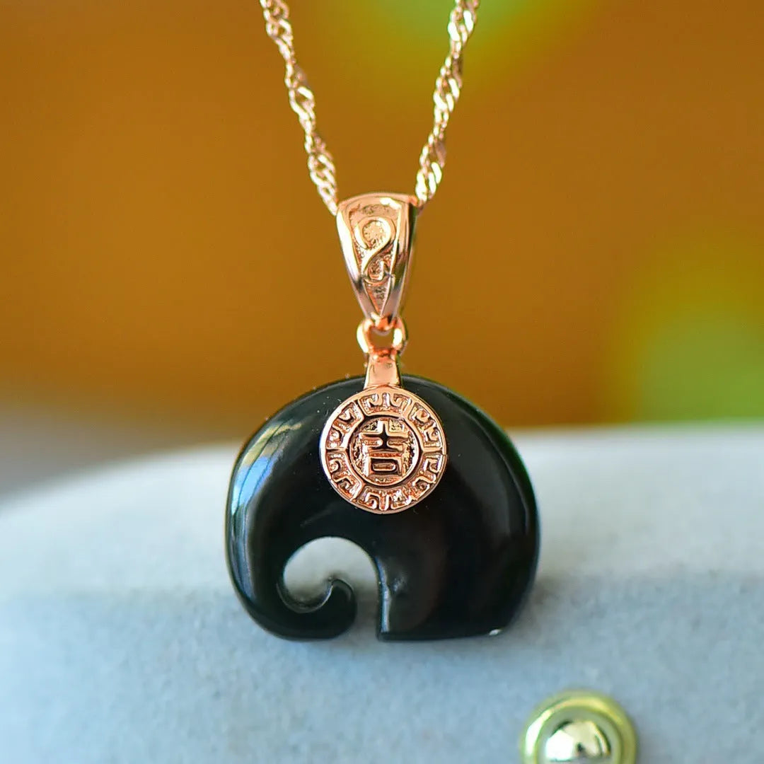 Close-up of a natural Hetian jade pendant with intricate copper inlay detail on a necklace chain.