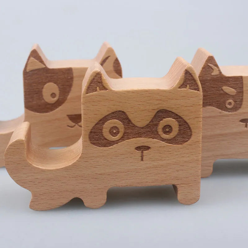 Decorative resin mobile phone stand in a choice of styles including animal figures and wood-effect designs.
