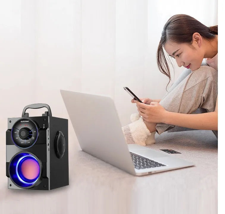 Black portable mini home audio system with subwoofer showing 3.5mm audio cable and USB power connection