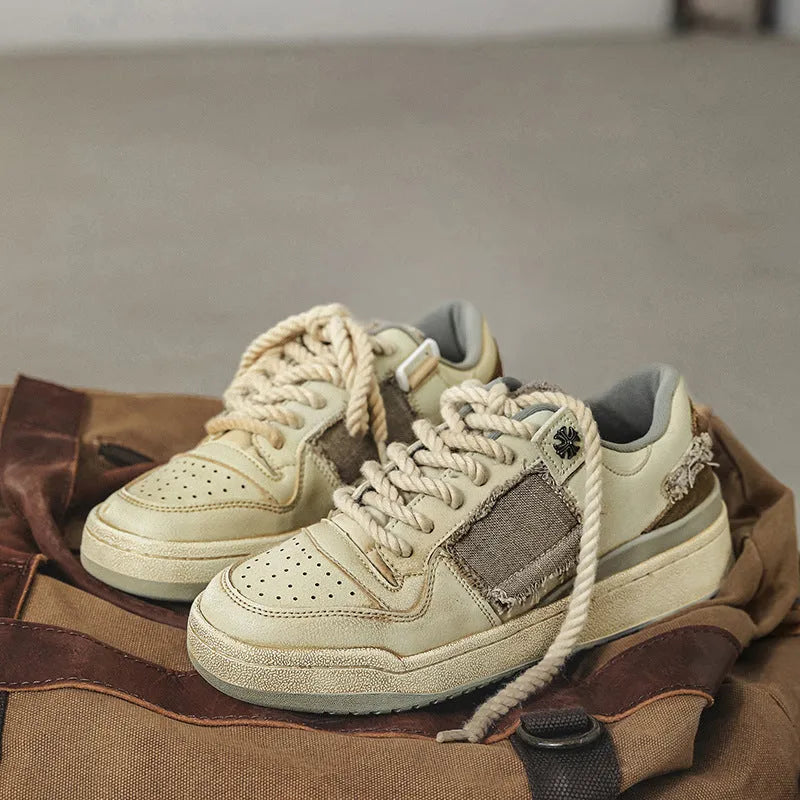 Beige low-top skateboard shoes with round toe and front lace-up closure on a flat rubber sole.