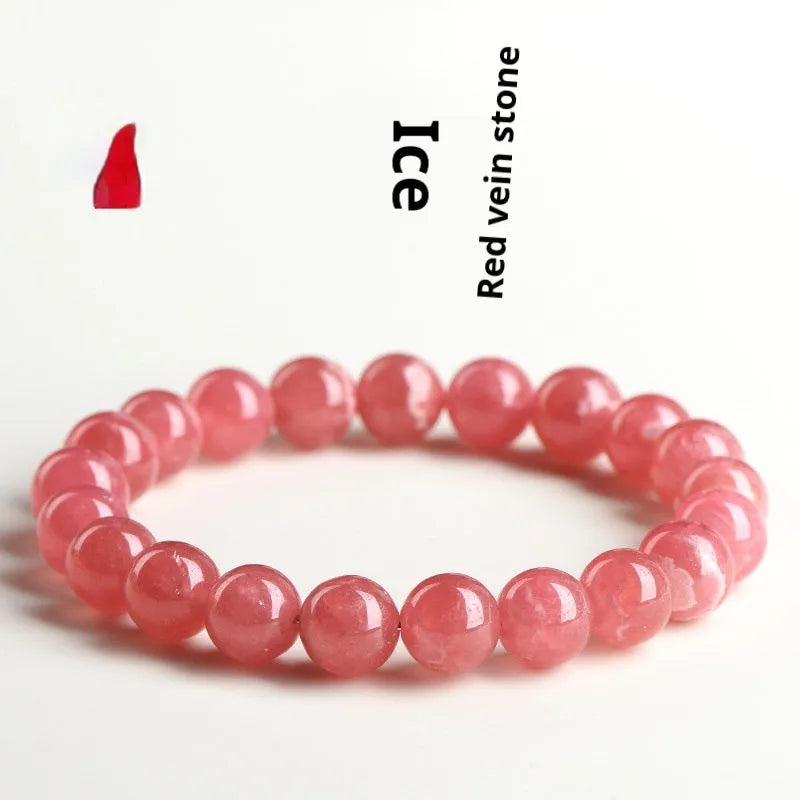 Women's red crystal bracelet with a geometric longevity lock clasp on a wrist.